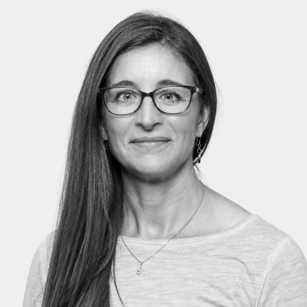 Black-and-white headshot of Kerry Thompson, wearing glasses and smiling at the camera.
