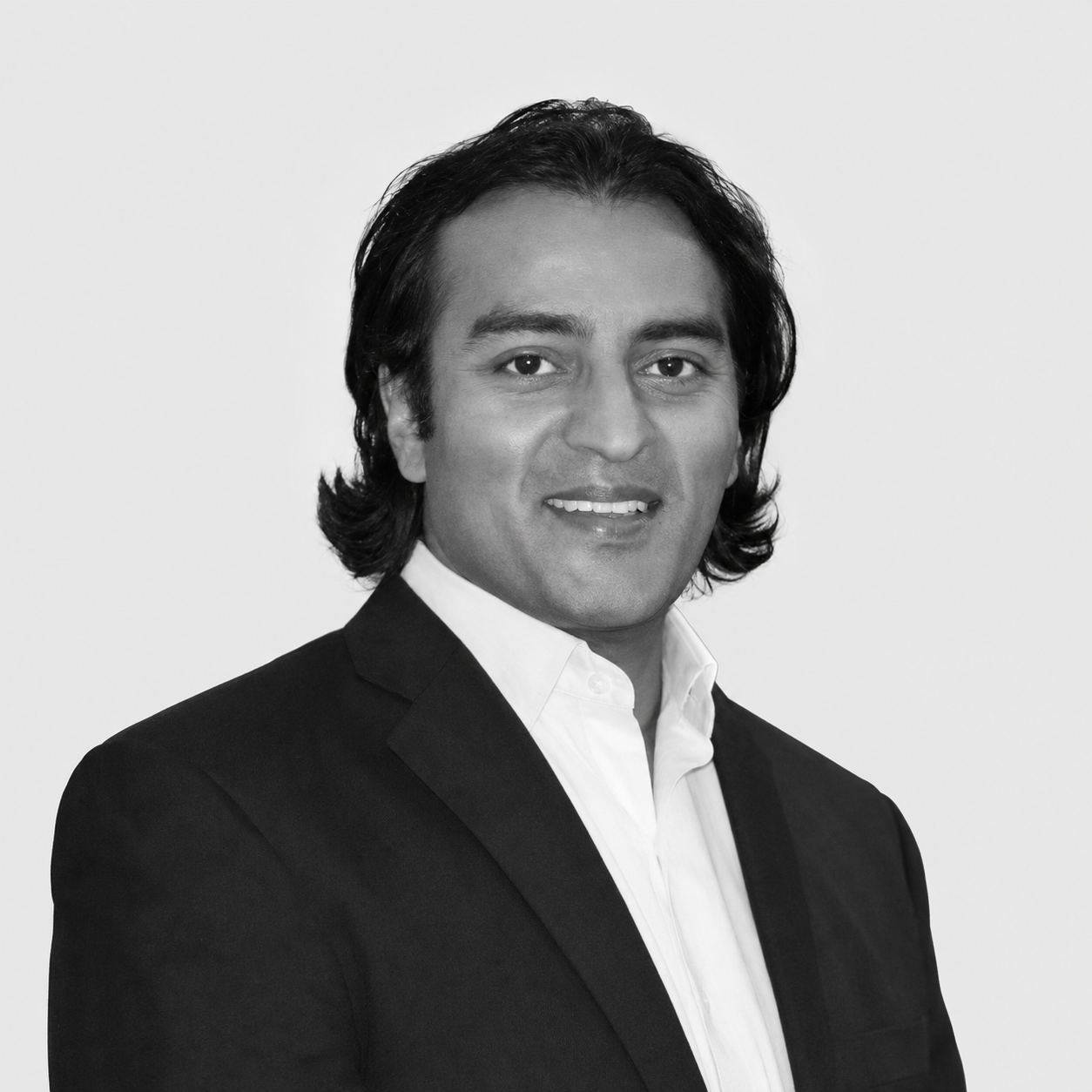 Black-and-white headshot of Marc Goodman, smiling and wearing a dark jacket and white shirt.