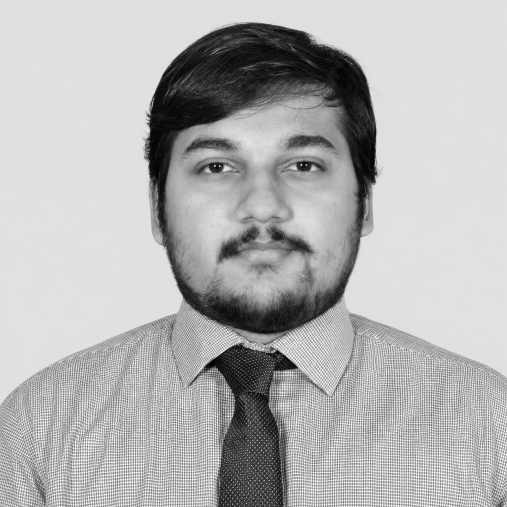 Black-and-white headshot of Shrayan Banerjee, wearing a shirt and tie and looking at the camera.